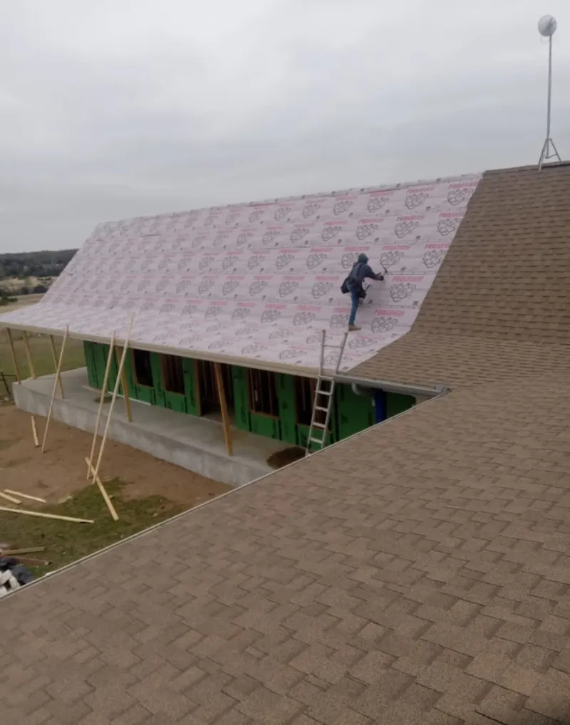 Worker preparing underlayment for a metal roof installation in Elizabethton